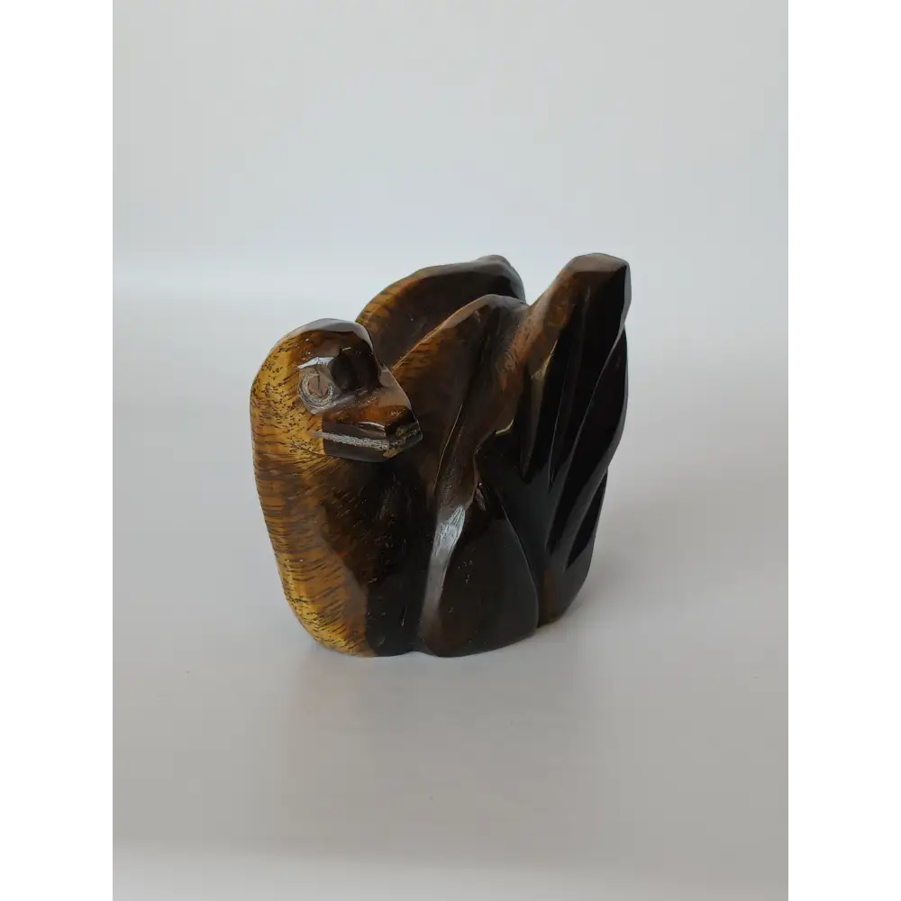 Assorted hand-carved animal figurines made from Blue Tiger’s Eye, Fluorite, and Tiger’s Eye crystals, each featuring unique colors and patterns, displayed on a white background.