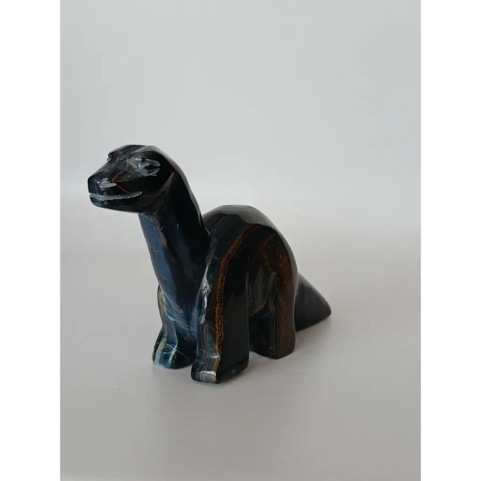 Assorted hand-carved animal figurines made from Blue Tiger’s Eye, Fluorite, and Tiger’s Eye crystals, each featuring unique colors and patterns, displayed on a white background.