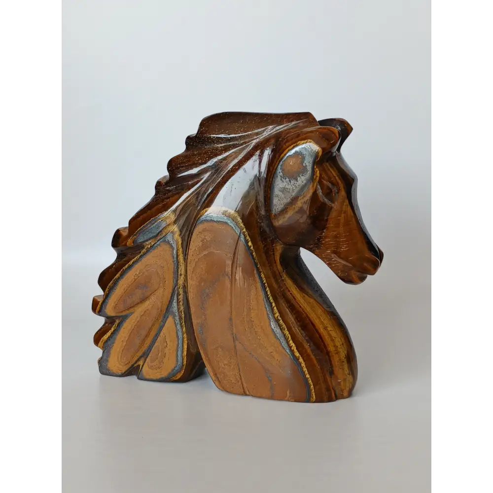 Assorted hand-carved animal figurines made from Blue Tiger’s Eye, Fluorite, and Tiger’s Eye crystals, each featuring unique colors and patterns, displayed on a white background.