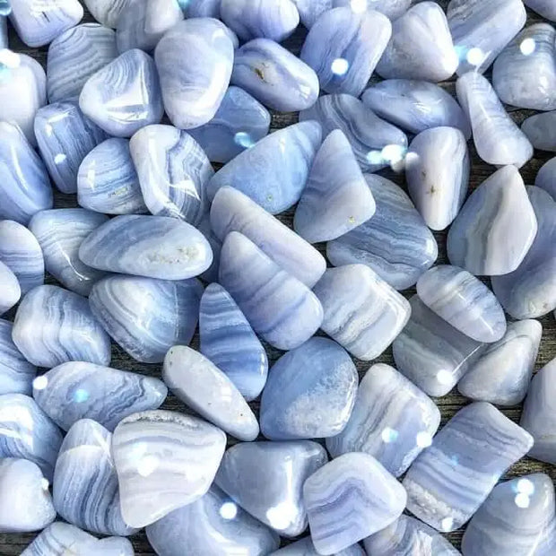 Polished blue lace agate tumble with soft blue and white bands, displayed on a white background. Perfect for calm, communication, and gentle healing.