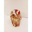 Carnelian skull with vibrant orange-red hues and natural banding, carved and displayed on a white background.