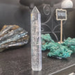 Hand-carved Clear Quartz tower featuring brilliant transparency and natural inclusions, displayed on a white background.
