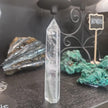 Hand-carved Clear Quartz tower featuring brilliant transparency and natural inclusions, displayed on a white background.