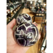 Hand-polished Dream Amethyst sphere featuring vivid purple and white chevron bands, displayed on a white background.
