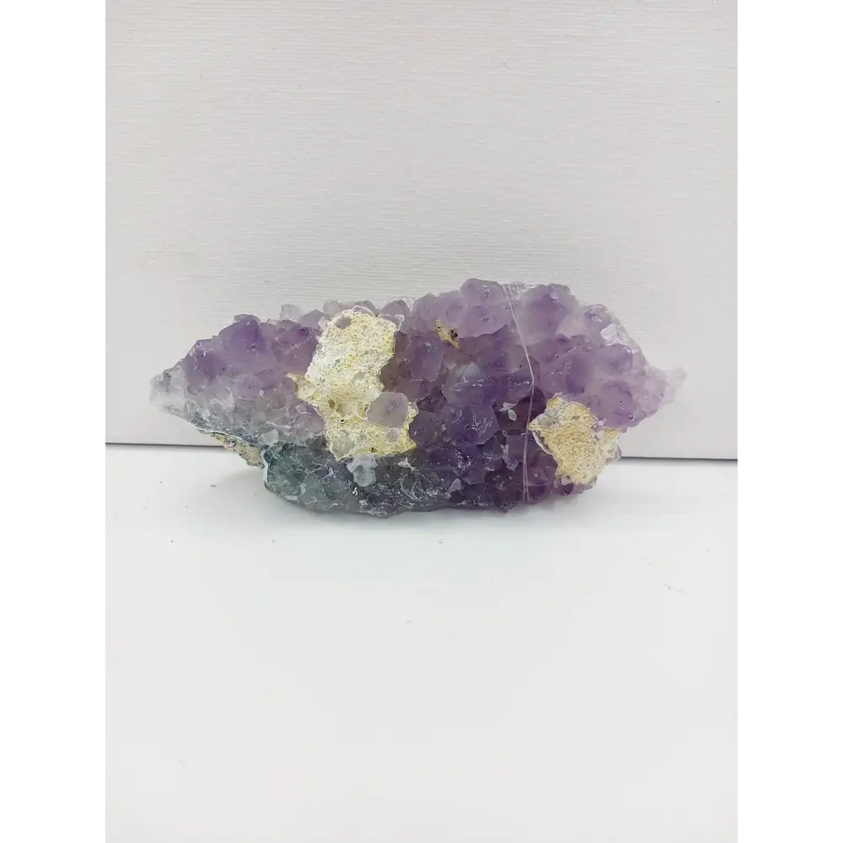 Fine glittery amethyst specimen, featuring sparkling purple points and a shimmering surface, displayed on a white background.
