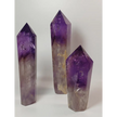 Polished freestanding Amethyst wand with deep purple hues and natural clarity, displayed on a white background.