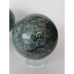 Hand-polished Green Mica sphere featuring sparkling, leafy-green hues and a glossy finish, displayed on a white background.