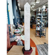 Huge clear quartz tower, polished and mounted on a sturdy stand, with brilliant clarity and natural inclusions, displayed on a white background.
