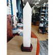 Huge clear quartz tower, polished and mounted on a sturdy stand, with brilliant clarity and natural inclusions, displayed on a white background.