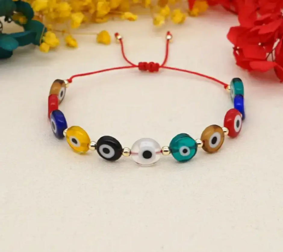 Colorful beaded bracelet with red string on a light background