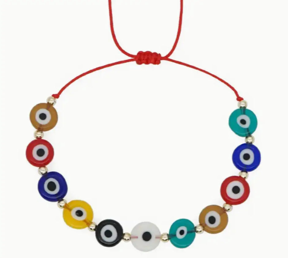 Necklace with colorful evil eye beads on a red cord against a white background