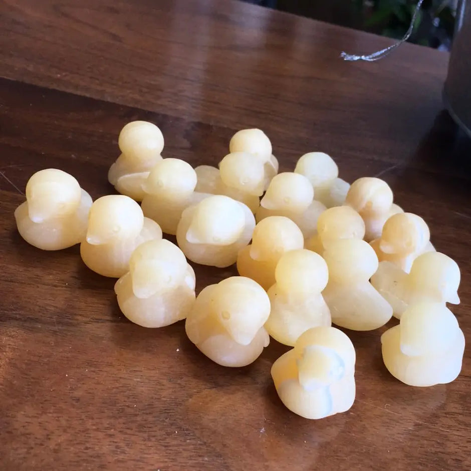 Hand-carved orange calcite mini duck with vibrant orange hues, displayed on a white background. Perfect for joy, playfulness, and creative energy.