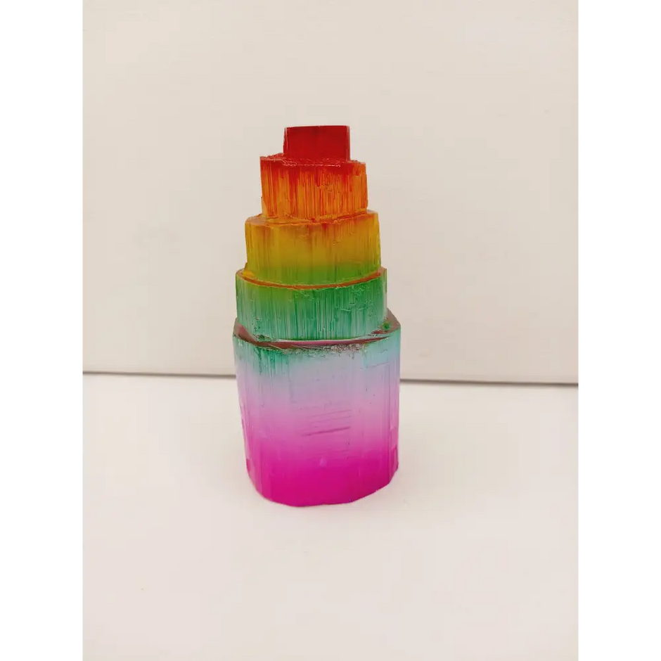 Rainbow selenite tiered tower, polished with a vibrant rainbow sheen and step-like design, displayed on a white background.