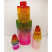Rainbow selenite tiered tower, polished with a vibrant rainbow sheen and step-like design, displayed on a white background.
