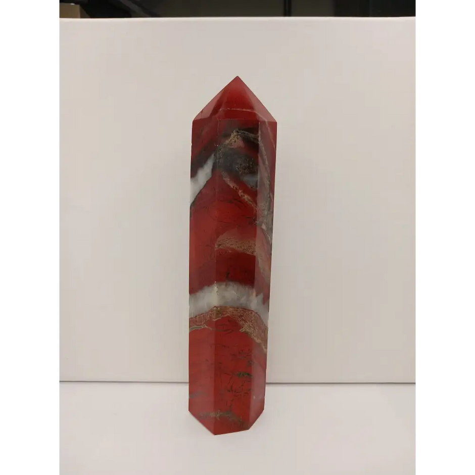 Hand-carved Red Jasper point with a clear quartz band, featuring vibrant red tones and a striking clear quartz stripe, displayed on a white background.