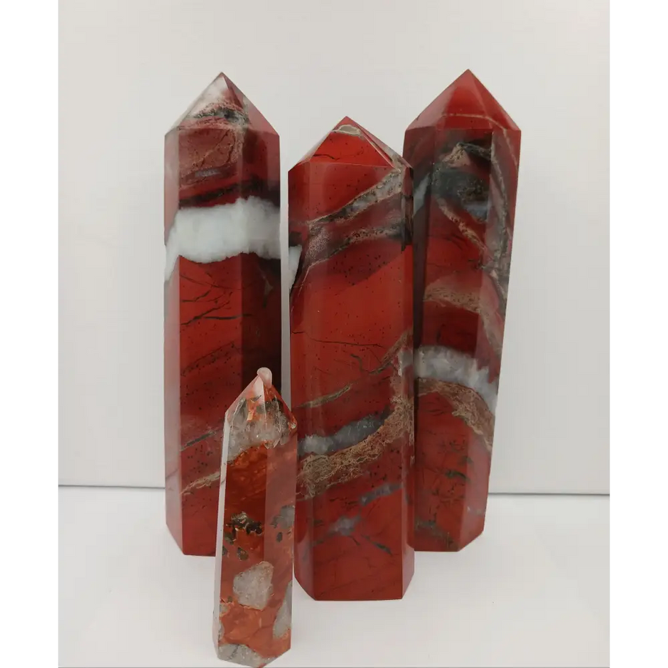 Hand-carved Red Jasper point with a clear quartz band, featuring vibrant red tones and a striking clear quartz stripe, displayed on a white background.