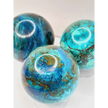 Turquoise sphere with vibrant blue-green color and natural veining, displayed on a white background.